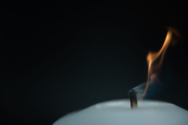 A closeup of a burning white candle