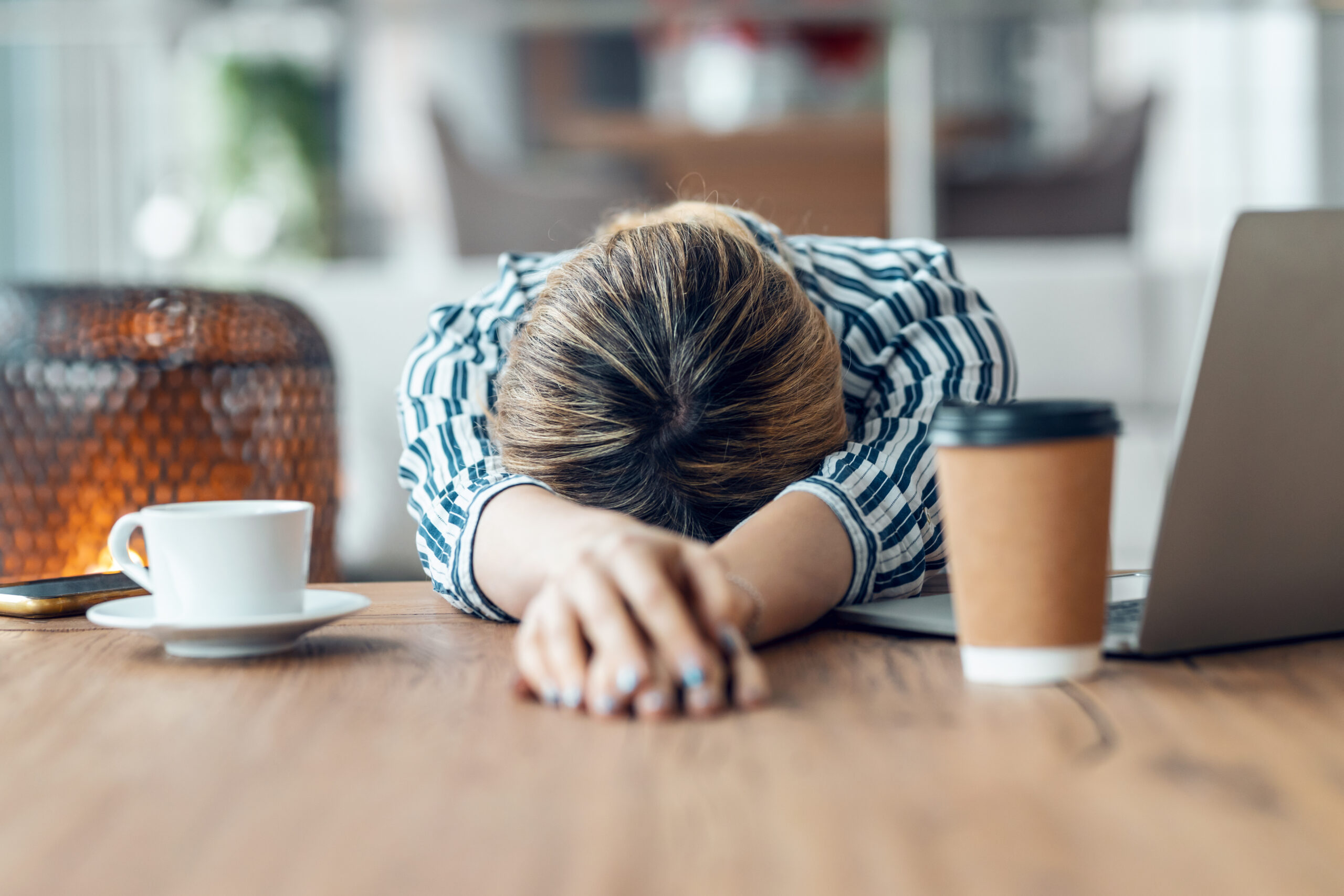 Shot of exhausted young business woman who has fallen asleep while working with laptop in living room at home.
