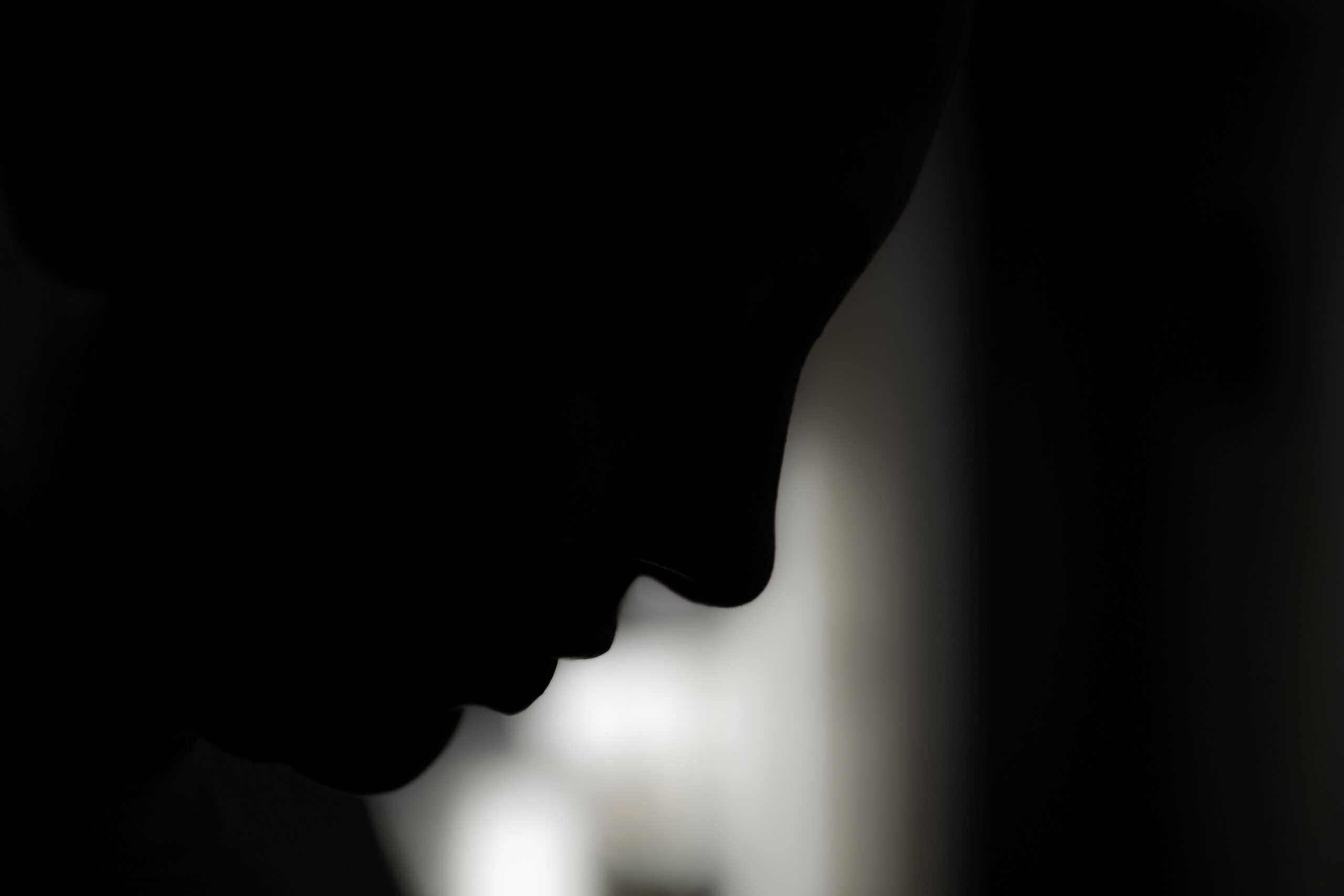 A profile of a woman emerges from the darkness.