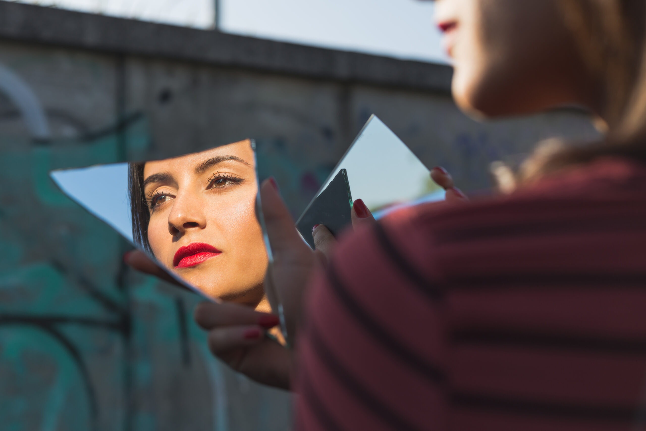 Girl posing with a broken mirror in an urban context