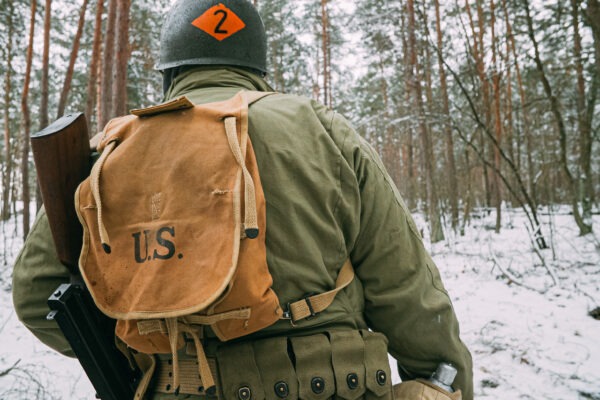American Infantry Soldier Marching Through Forest Road In Cold Winter Day.
