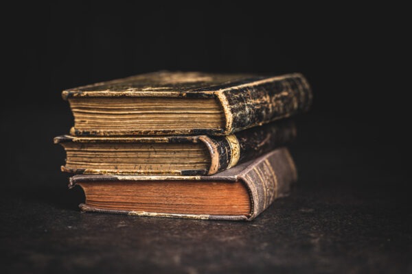 Old antique books on a black table.
