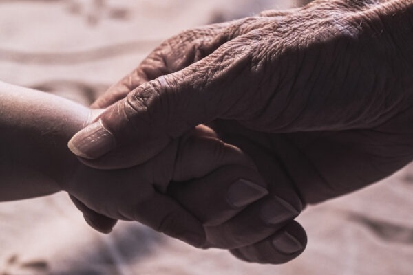 Grandfather holding his grandson's hand.
